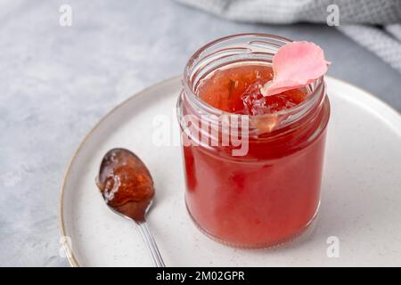 Closeup of rose jam on neutral background with spoon and plate Stock Photo