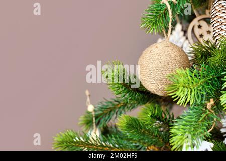 Christmas tree branches with natural ornament bauble made from beige jute robe with copy space Stock Photo