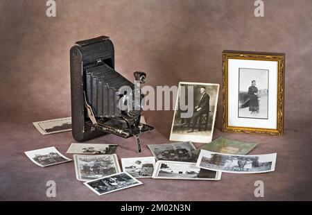 A vintage, 1926, Kodak folding pocket camera, 21/4 x 21/4 bellows camera with photographs that could have been made by a similar camera. Stock Photo