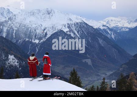 Verbier, Switzerland. 3rd Dec, 2022. The winter season officially opens in the Verbier 4Vallées ski area. As per tradition, thousands of skiers and snowboarders dress up as St. Nicholas or Santa Claus and receive a discount to ski for the day. Two skiers stop atop a ridge and admire the view towards Val de Bagnes before continuing on. Credit: Aldercy Carling/ Alamy Live News Stock Photo