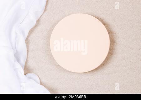 Empty round beige platform podium and white crumpled linen fabric cloth on white natural beach sand background. Minimal creative composition Stock Photo