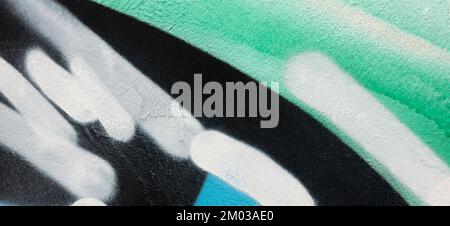 Fragment of old plaster wall with graffiti painting. Part of colorful street art graffiti on wall background. Youth, urban culture. Green, black Stock Photo