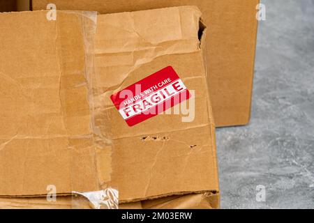 Damaged cardboard box with fragile label. Package insurance, mail delivery and shipping deadline concept Stock Photo