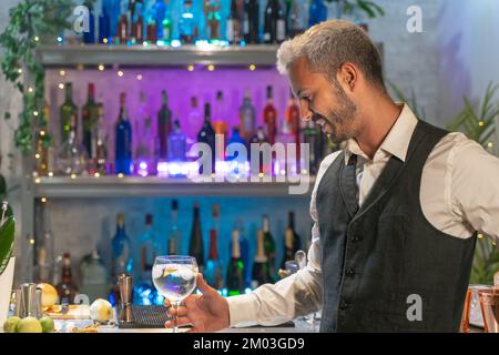 Professional barman looking cocktail in nightclub. Night life concept Stock Photo