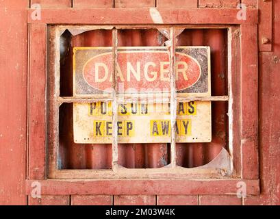 Danger sign warning of broken glass on the top of a wall, England Stock ...