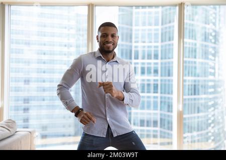 Happy handsome young African man having fun indoors, Stock Photo