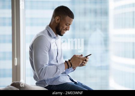 Cheerful African mobile phone user man using online app Stock Photo