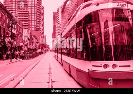 Color of year 2023 Viva Magenta. Image with streetcar in downtown is toned in pantone color of viva magenta. New Fashion colour. Close view of TTC tra Stock Photo