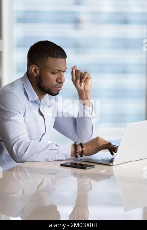 Focused busy millennial Black business leader man typing on laptop Stock Photo