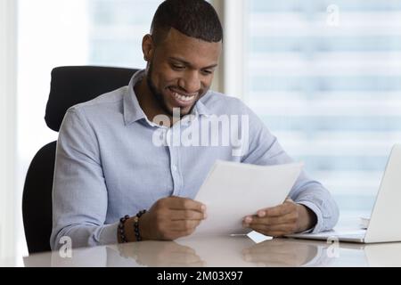 Happy satisfied African American business leader man receiving good news Stock Photo