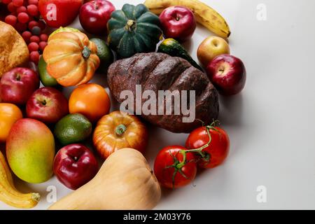 On the table like a background, there is a harvest of fruits and vegetables. Stock Photo