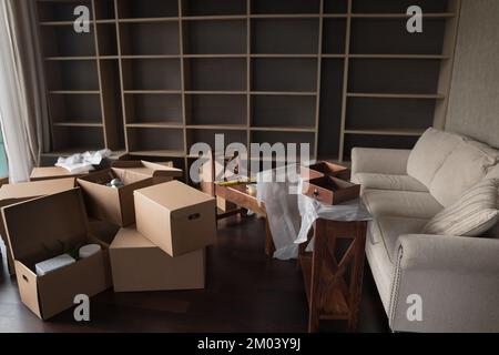 Mess of cardboard moving boxes stacked on floor Stock Photo