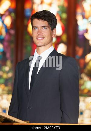 Groom-to-be. Portrait of a young groom standing in front of stained glass windows. Stock Photo