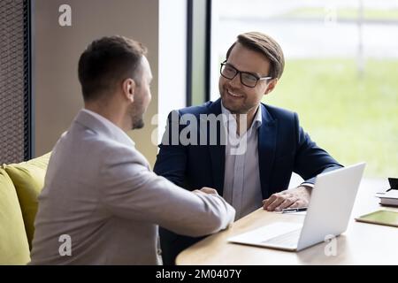 Businessmen shake hands close deal after successful negotiations in office Stock Photo