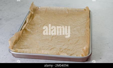 Baking pan with parchment paper close-up on the kitchen table, copy space Stock Photo