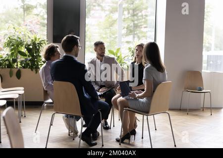 Office employees gathered for morning briefing in modern workspace Stock Photo