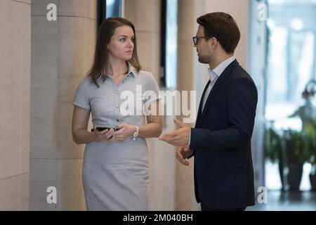 Two colleagues talking meet in modern office hallway Stock Photo