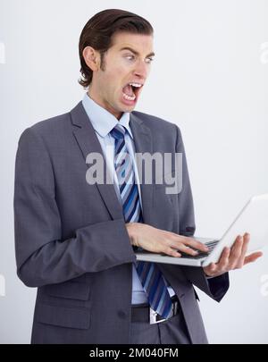 Not again. A crazy businessman screaming at his laptop screen as it stalls once again. Stock Photo