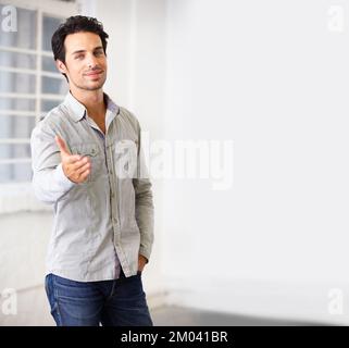 Welcome, come and see what we do here. Portrait of a handsome young businessman extending a hand to welcome you. Stock Photo