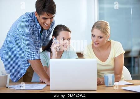 Getting their clients approval. three colleagues working in an office. Stock Photo