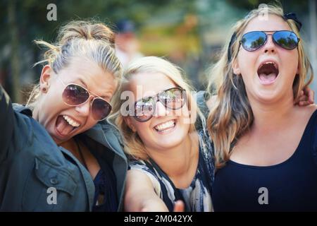 Scream if you love it. Three young friends rocking out to a band at a music festival. Stock Photo