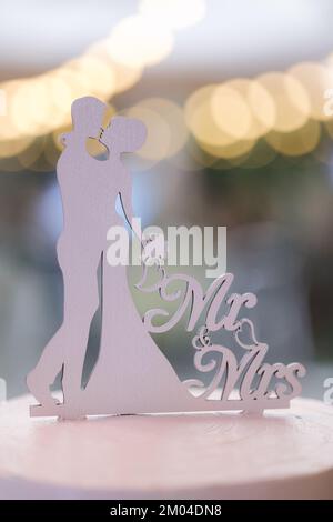 Mr and Mrs on wedding cake. Beautiful white wooden molds of bride and groom Stock Photo