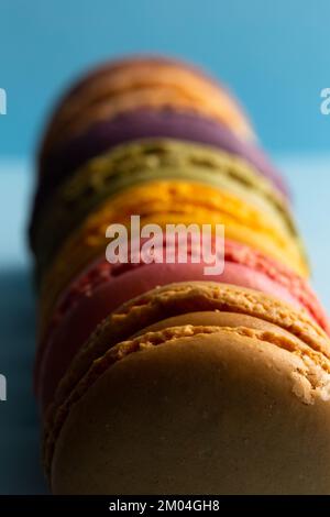 colored macaroons in a row on a blue background Stock Photo