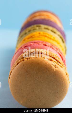 colored macaroons in a row on a blue background Stock Photo