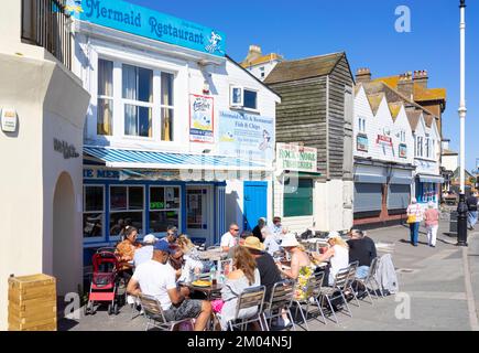 Hastings Old Town People eating fish and chips outside the Mermaid restaurant Hastings old Town Hastings East Sussex England UK GB Europe Stock Photo