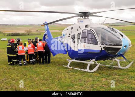 An emergency helicopter is loaded with an injured person by firefighters and health workers after having a traffic accident.