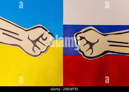 two cardboard fists on flags of Russia and Ukraine. Russian versus Ukraine trade third world war disputes and anctions policy concept Stock Photo
