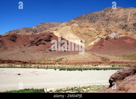 The Hari River (Harirud) near Chisht-e-Sharif in Herat Province, Afghanistan. A view of the river bank with colorful mountain scenery. Stock Photo