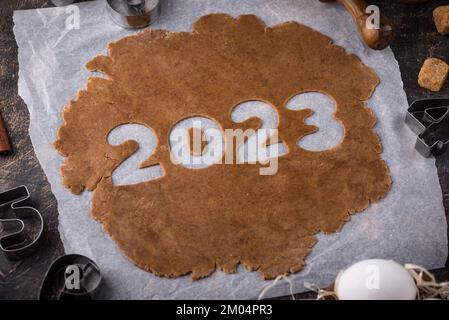 Gingerbread dough for cookies in shape of 2023 Stock Photo
