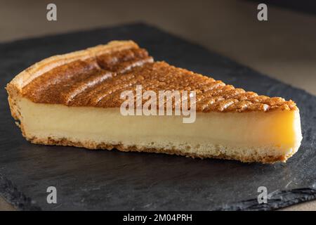 Slice of Parisian Flan (French Custard Pie) Classic tart. Baked confectionery cream in shortbread dough crust. Stock Photo