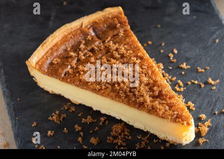 Slice of Parisian Flan (French Custard Pie) Classic tart. Baked confectionery cream in shortbread dough crust. Top view Stock Photo