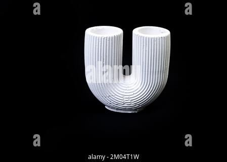 gypsum column with a bowl, a vase with stucco moldings in the form of floral ornament, plaster vase in the form of an antique column. Modern art. Mode Stock Photo