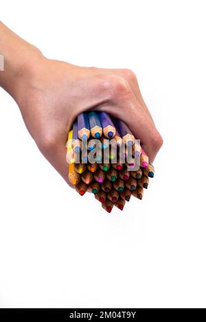 Multi-colored pencils for drawing in a female hand. multi-colored pencils in female hand on white background, Close up, copy space, Modern art. Modern Stock Photo