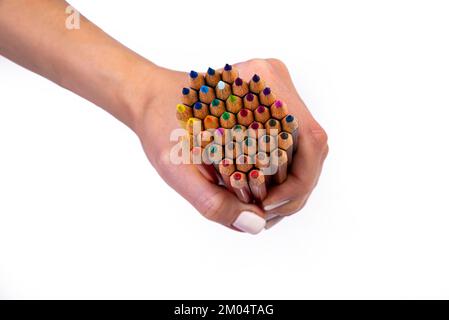 Multi-colored pencils for drawing in a female hand. multi-colored pencils in female hand on white background, Close up, copy space, Modern art. Modern Stock Photo