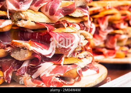 traditional Spanish bocadillos with Iberico jamon laid out in a slide on a shop window Stock Photo