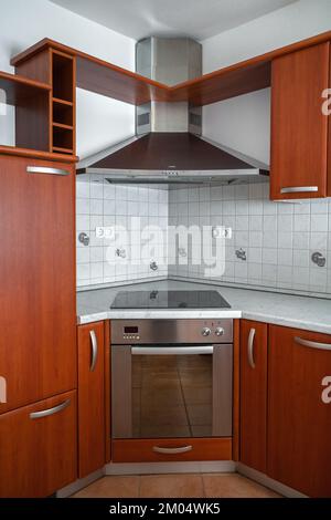 A kitchenette with a stove and hood in the modern kitchen of the apartment Stock Photo