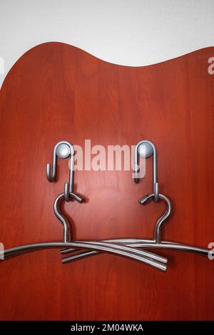 Two modern metal hangers for clothes, hung in the anteroom of the apartment Stock Photo