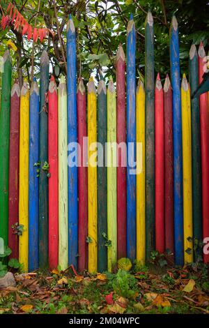Garden fence in the form of large colored pencils in different colors Stock Photo