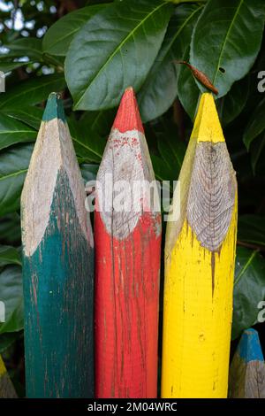 Close up of a garden fence in the form of large colored pencils in different colors Stock Photo