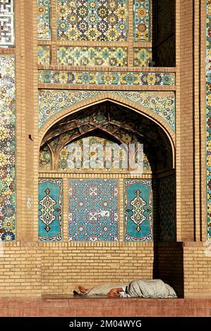 Herat in western Afghanistan. The Great Mosque of Herat (Friday Mosque or Jama Masjid). People resting in an alcove at the front of the mosque. Stock Photo