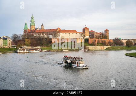 Wawel Royal Castle view and Vistula River cruise tour boat. Krakow, Poland - November 11, 2022. Stock Photo