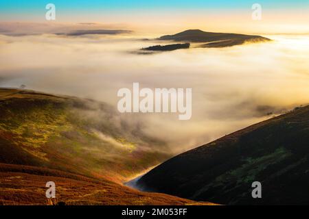 Win Hill rising above the valley mist, as seen from Kinder Scout in the Peak District National Park Stock Photo