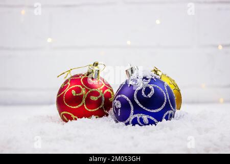 Christmas toys on a light background, in artificial snow. Selective focus Stock Photo