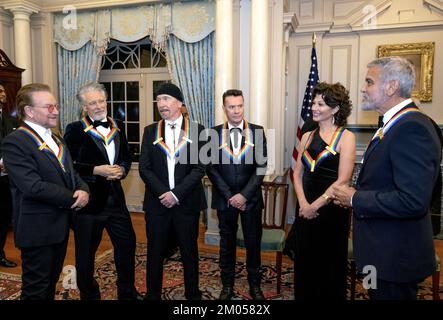Washington DC, USA. 03rd Dec, 2022. From left to right: Bono, Adam Clayton, The Edge, Larry Mullen Jr., Amy Grant and George Clooney converse as they wait to pose for a group photo following the Artists Dinner at the US Department of State in Washington, DC on Saturday, December 3, 2022. Credit: UPI/Alamy Live News Stock Photo