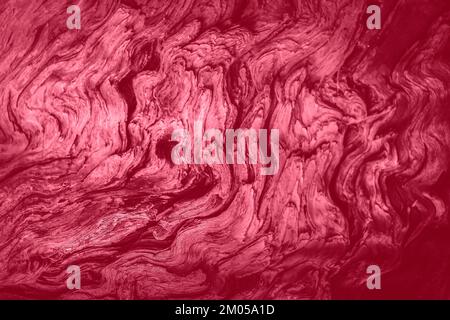 Mysterious grunge woody background with soft focus of winding fibers of old weathered cracked wood. Trendy toning in color 2023 Viva Magenta. Stock Photo