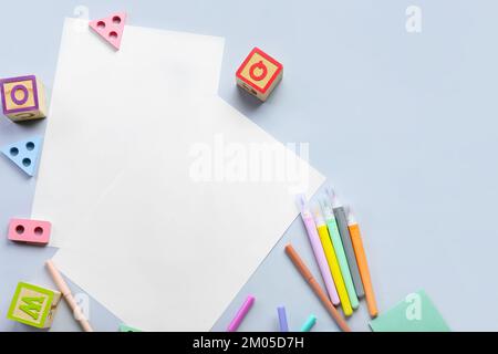 Blank paper sheets with felt-tip pens and educational toys on light background Stock Photo